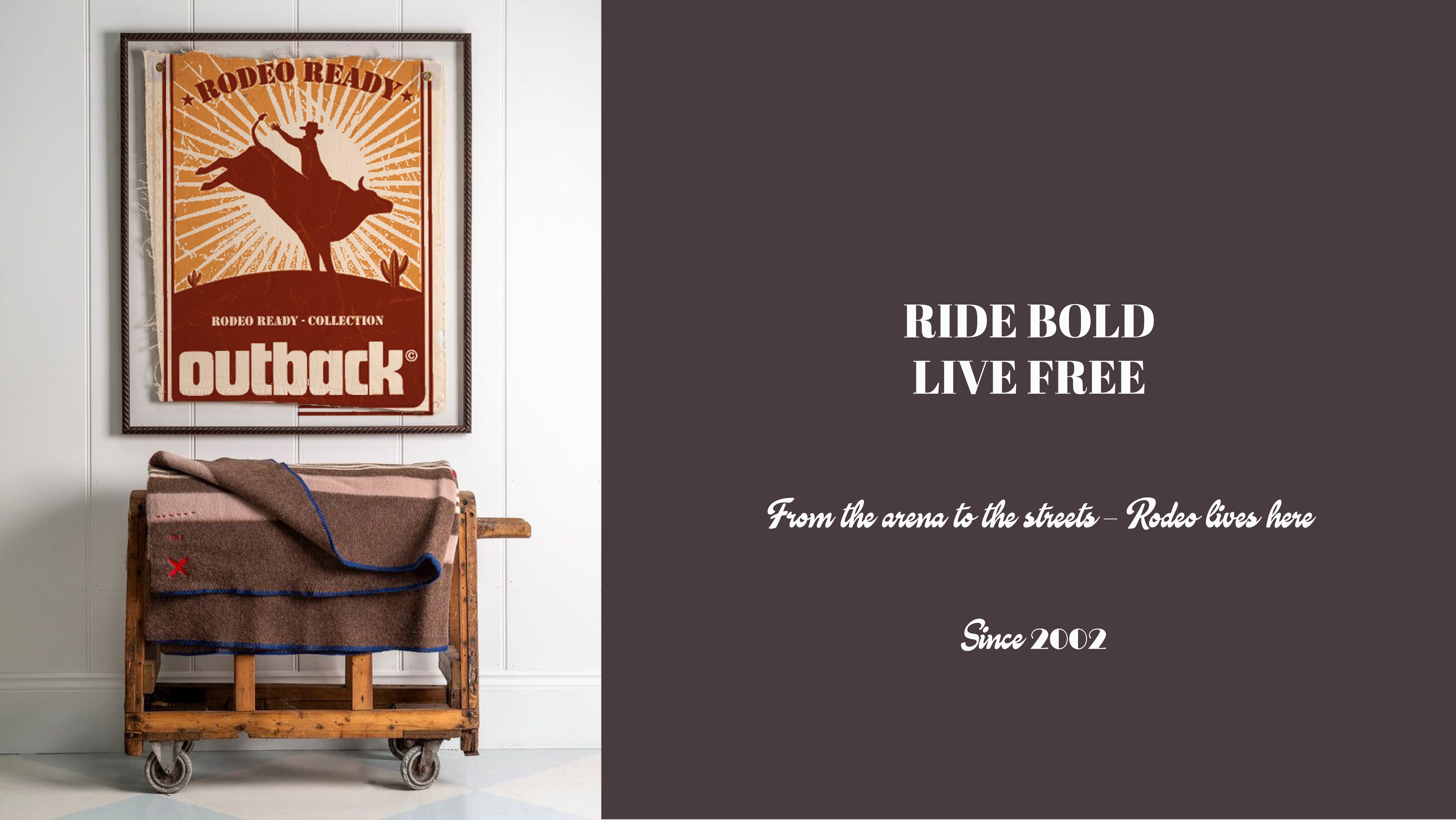 Wooden cart with blankets next to a framed Outback Rodeo Ready Collection poster on a white wall.